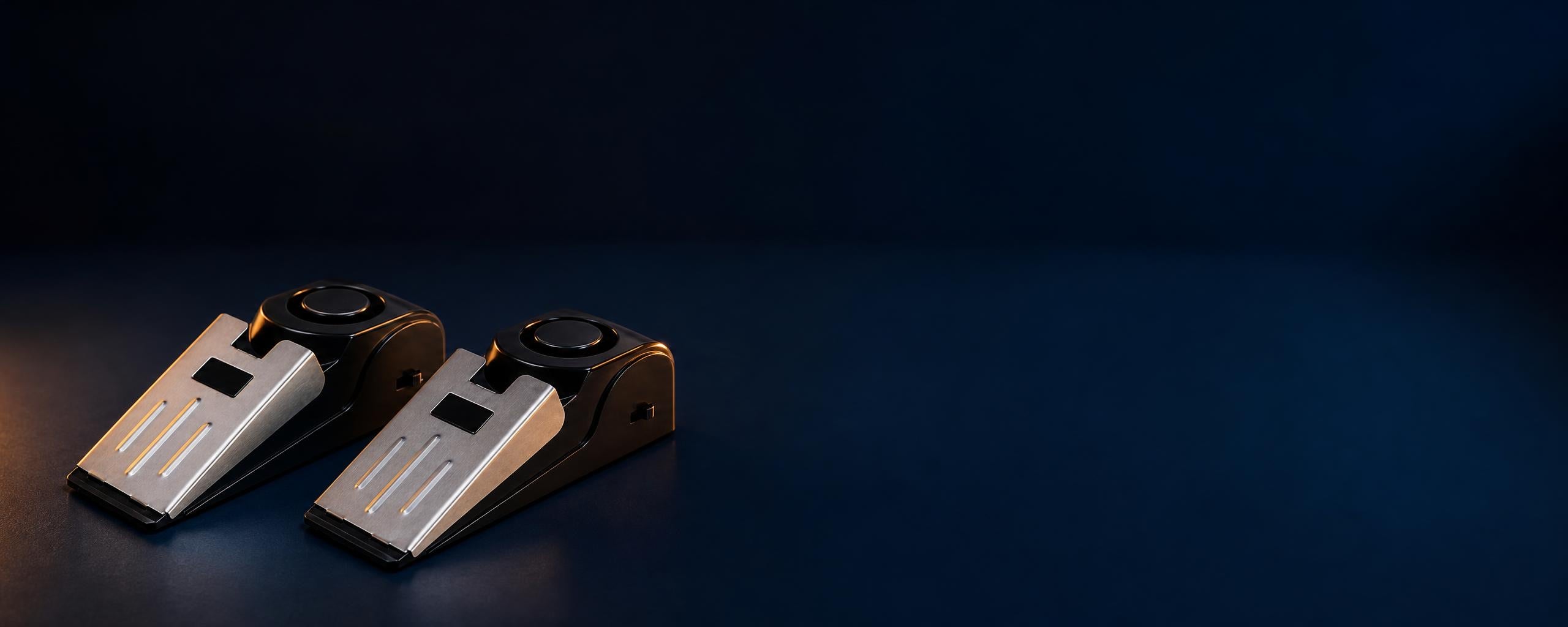 Two DoorGuard alarms on a dark surface